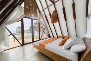 a bedroom with a bed and a large window at El Embrujo Tintipan in Tintipan Island