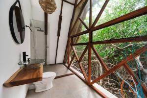 a bathroom with a toilet and a large window at El Embrujo Tintipan in Tintipan Island +78 photos