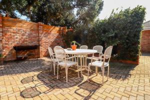 a table and chairs sitting on a brick patio at Magna Apartment in Jeffreys Bay