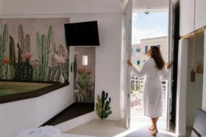 a woman in a white dress walking into a room at Monsignore Luxury Suite in Monopoli