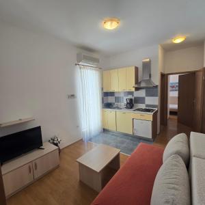 a living room with a couch and a kitchen at Pansion Bonaca in Srima