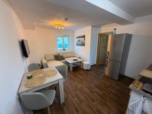 a kitchen and a living room with a table and a refrigerator at Apartmán Špičák in Špičák