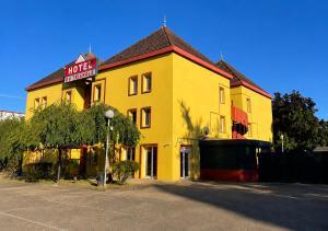a yellow building with a sign on top of it at Hotel du Triangle in Talange