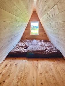 a bed in a small room with a window at 自然満喫 野上平ロッジ in Kirishima