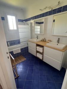 a bathroom with two sinks and a mirror and blue tiles at La Maison d'Orange - Au calme à 2 pas du Théâtre Antique in Orange +13 photos