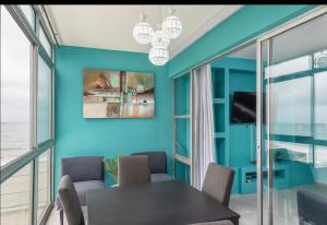 a dining room with blue walls and a table and chairs at 94 Camarque Umdloti in Umdloti