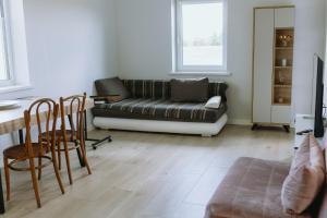 a living room with a couch and a table at Obsenieki - moderna lauku sēta in Stalidzāni
