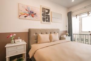 a bedroom with a large bed and a nightstand with flowers at Morden Apt 6Br Old Quater in Hanoi