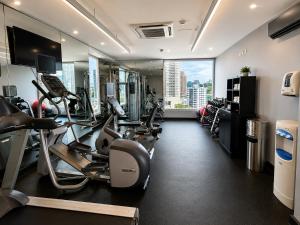 a gym with cardio machines and a large window at The District Hotel in Panama City