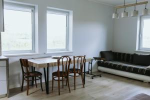 a living room with a table and chairs and a couch at Obsenieki - moderna lauku sēta in Stalidzāni