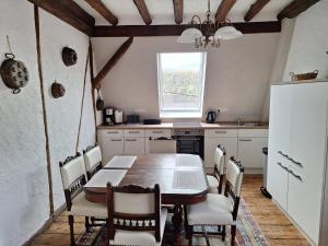 a kitchen with a table and chairs and a refrigerator at Wunderschönes Winzerhaus Schenk in Neef