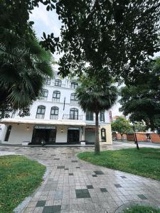 a white building with a tree in front of it at Olivea Boutique Hotel Phu Quoc in Phú Quốc