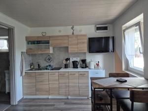 a kitchen with wooden cabinets and a table at Auszeit in Balatonmagyaród