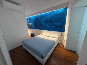 a bed in a room with a blue painting on the wall at Mare Mosso 2 in Manarola