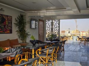 a restaurant with tables and chairs and a balcony at Panorama Ramsis Hotel & Cafe in Cairo