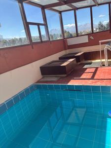 a swimming pool in a house with windows at La Casa Junto Al Rio in Arequipa