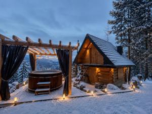 a log cabin with a hot tub in the snow at Góralska Chatka jacuzzi in Kościelisko