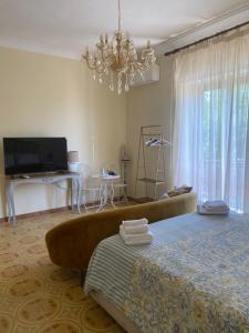 a bedroom with a bed and a television and a chandelier at Villa Favorita Suites in Ercolano