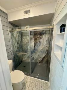 a small bathroom with a shower and a toilet at Caribbean LYMM Cottage in Carolina Beach