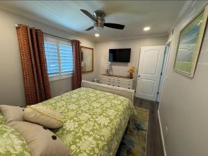 a bedroom with a bed and a ceiling fan at Caribbean LYMM Cottage in Carolina Beach