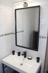 a bathroom with a white sink and a mirror at Le Clos Cecile'Ann in Fréchou +20 photos