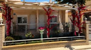 a house with red flowers on the front porch at The Garden Apartments in Nea Kallikrateia +3 photos