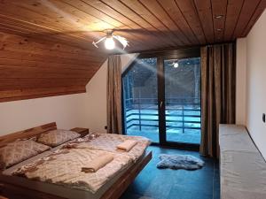 a bedroom with a bed and a large window at Chalet Martinky in Martin