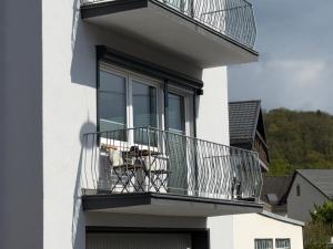 a balcony of a white building with a table on it at APARTMENT in Hambach in Hambach
