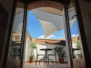 a glass door leading to a patio with a table and chairs at B&B La Pecora Nera in Belluno