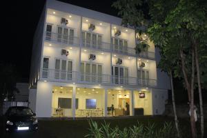 a white building with a car parked in front of it at Heaven By O in Unawatuna