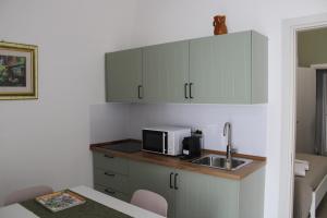 a small kitchen with a sink and a microwave at Dimora Letizia, Apulian Rooms in Sammichele di Bari