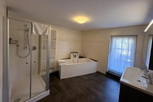 a bathroom with a tub and a shower and a sink at Ferienwohnungen Hopfenhaus in Spalt