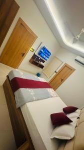 a bedroom with a bed with red pillows on it at Mangalam Palace Vrindavan in Chhatikara