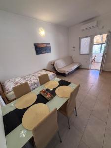a living room with a table and chairs and a bed at Apartmani Milka in Vrsi