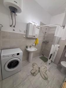 a bathroom with a washing machine and a sink at Apartmani Milka in Vrsi +12 photos
