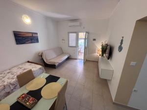 a small living room with a bed and a table at Apartmani Milka in Vrsi