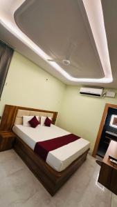 a bedroom with a bed in a room with a ceiling at Mangalam Palace Vrindavan in Chhatikara