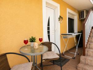 a table with two glasses of wine and two chairs at Apartment Vrančić in Šibenik