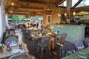 a restaurant with tables and chairs and a bar at Hotel Les Messugues in Saint Paul de Vence