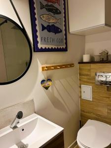 a bathroom with a white sink and a mirror at Ustka- Wakacyjny Domek Letni Wiatr in Ustka +32 photos
