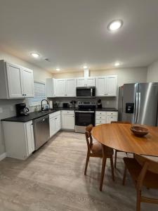 a kitchen with white cabinets and a wooden table at Lake of the Ozarks Waterfront Kapilana Resort Condos - Pool, Dock, Grill, Boat Rentals Fishing & Lake Views in Osage Beach