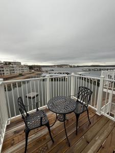 two chairs and a table on a deck with the ocean at Lake of the Ozarks Waterfront Kapilana Resort Condos - Pool, Dock, Grill, Boat Rentals Fishing & Lake Views in Osage Beach
