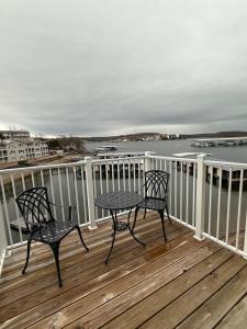 two chairs and a table on a deck overlooking the water at Lake of the Ozarks Waterfront Kapilana Resort Condos - Pool, Dock, Grill, Boat Rentals Fishing & Lake Views in Osage Beach