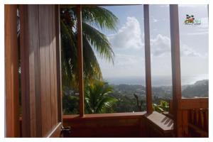 a room with a window with a view of a palm tree at Island View Estate in Kingstown