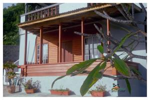 a house with a porch with potted plants in front of it at Island View Estate in Kingstown +5 photos