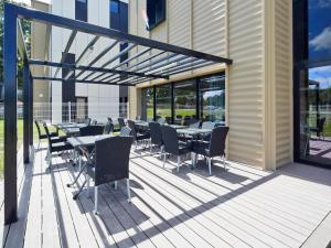 eine Terrasse mit Tischen und Stühlen auf einem Gebäude in der Unterkunft Kyriad Prestige Pau – Palais des Sports in Pau