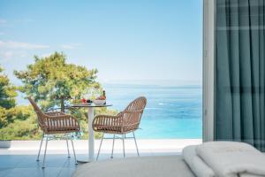 a patio with a table and chairs and the ocean at Gloria Luxury Suites in Kallithea Halkidikis +55 photos