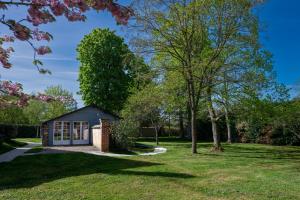 a small cottage in a park with trees at Gites de Coulonge in Coulonges-Ardennes +7 photos