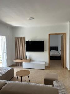 a living room with a couch and a tv on the wall at Villa Del Sol in Golem