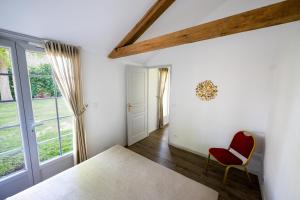 a bedroom with a bed and a red chair at Gites de Coulonge in Coulonges-Ardennes